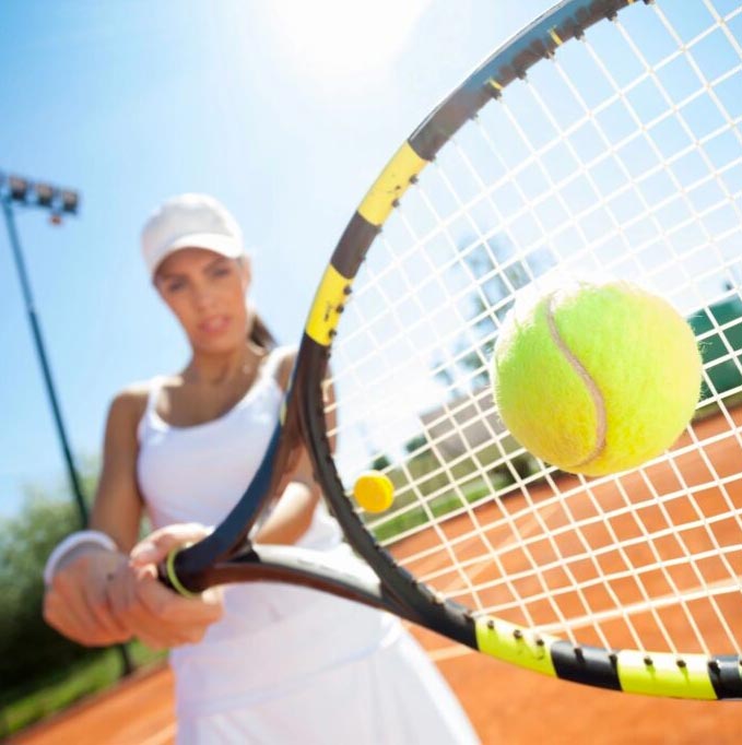 woman playing tennis with white outfit on